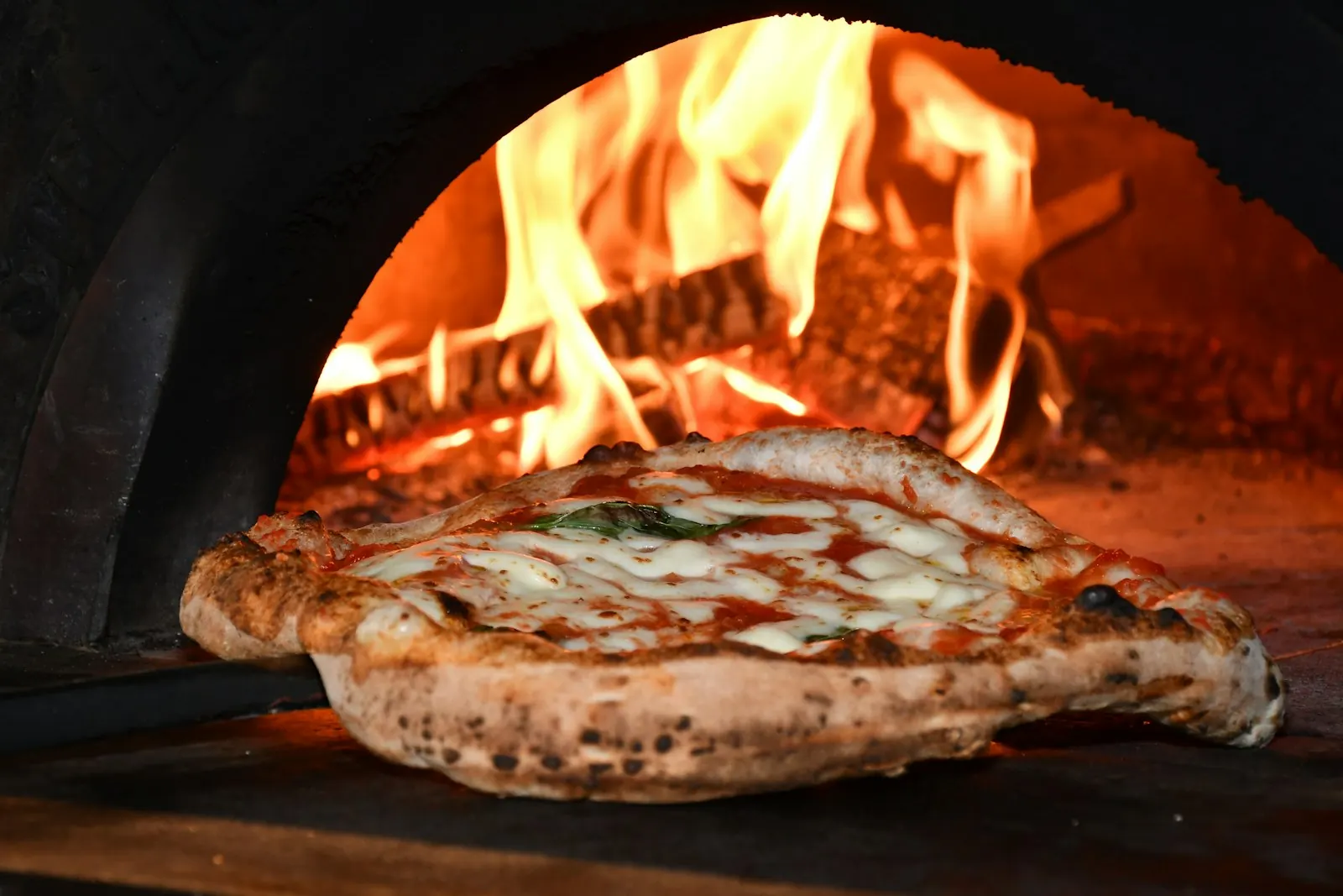 Pizza qui cuit dans le four à bois